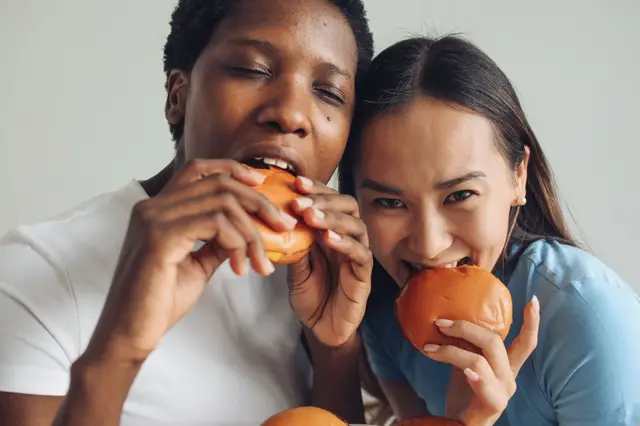 Dos amigas comiendo hamburguesas